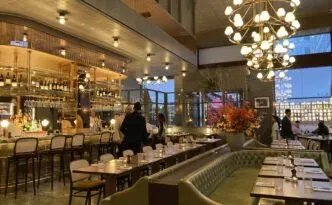 A richly lit dining room with tables set for dinner